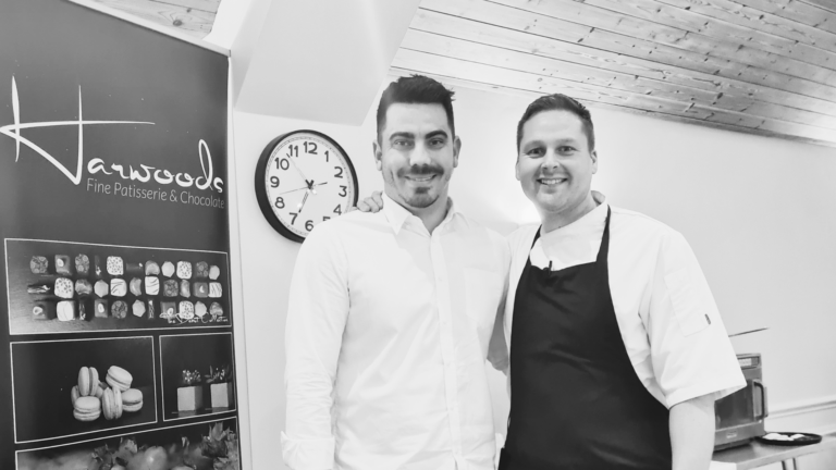 Andrew Harwood and Raf standing beside a roller banner for Harwood's Patisserie
