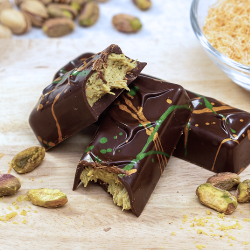Callebaut 811 dark chocolate bars filled with Keylink pistachio spread and roasted kadaif, decorated with coloured cocoa butter.